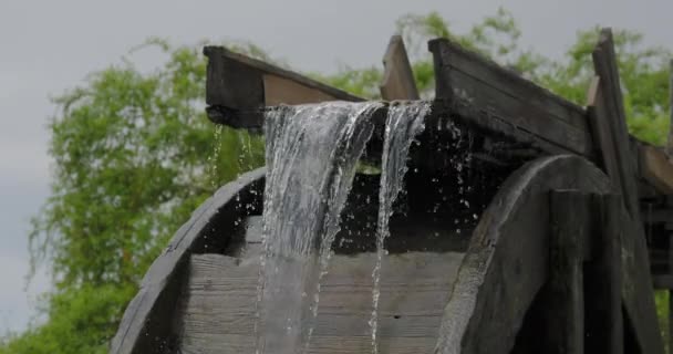 Strömendes Wasser dreht das hölzerne Rad einer alten Wassermühle. — Stockvideo