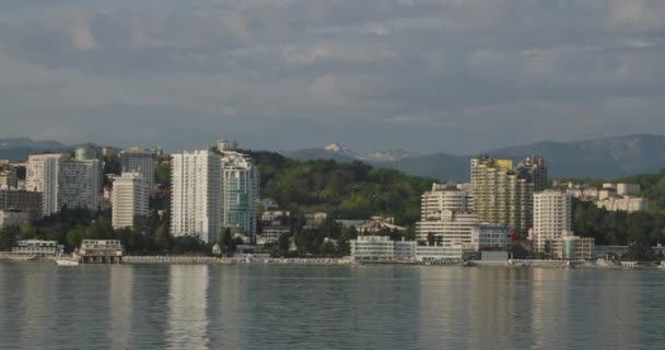 SOCHI, RUSSIA - 03 maja 2021 r. Panorama Soczi z pokładu poruszającej się łodzi. Światło zachodu słońca na budynkach. — Wideo stockowe