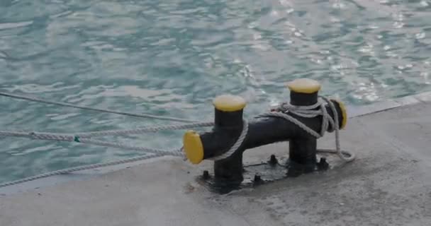 Putas costeras con cuerdas de amarre. Postes metálicos verticales emparejados montados en el muelle. Los postes se utilizan para asegurar líneas de amarre, cuerdas, transportistas o cables. — Vídeos de Stock