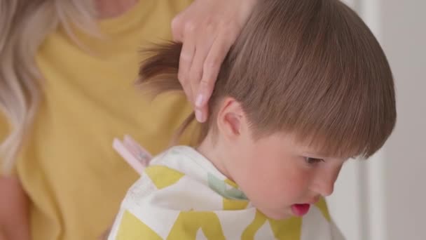 A própria mãe corta o cabelo dos filhos em casa. Novo normal. Fechar. — Vídeo de Stock