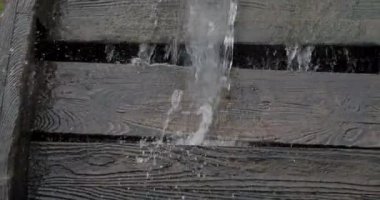 Akan su akıntısı eski bir su değirmeninin ahşap çarkını döndürür.
