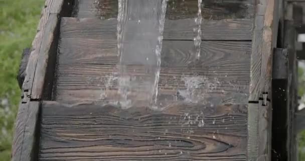 Proud tekoucí vody otáčí dřevěné kolo starého mlýna na vodu. — Stock video