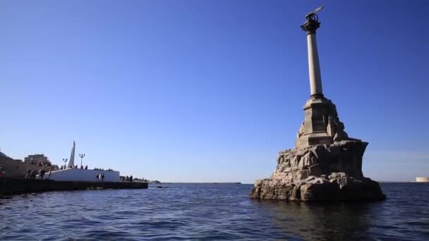 СЕВАСТОПОЛ, 4 октября. Люди ходят по набережной возле памятника затонувшим кораблям. — стоковое видео