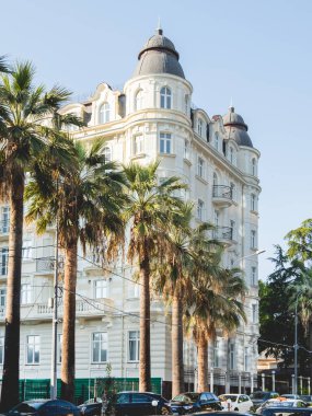 SOCHI, RUSSIA - May 27, 2021. Facade of apartment hotel Matisse. Beautiful building with palm trees alley at sunny day.