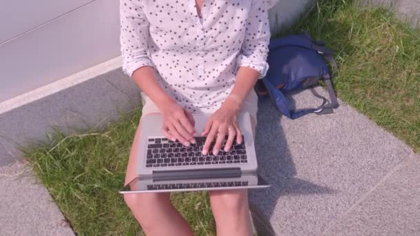 도시 공원에서 노트북을 가지고 일하는 여성의 꼭대기 사진. 여름에 프리랜서들을 위한 옥외 작업장. — 비디오