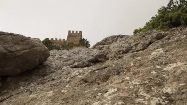 Sudak kasabasındaki antik Ceneviz kalesinin alt manzarası. Bulutlu bir günde tarihi mimari dönüm noktası. Kırım.