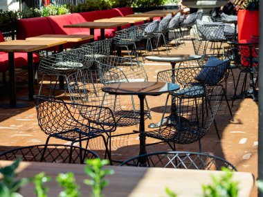 Issız bir sokak kafesi. Coronavirus COVID-19 pandemik karantina ve tecrit nedeniyle boş masa ve sandalyeler. 