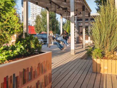 MOSCOW, Rusya - 22 Ağustos 2021. Yerel halk ve turistler Novy Arbat sokağında salıncakta sallanıyor. Sıcak yaz günbatımı.