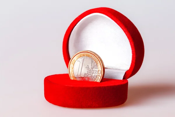 Czerwone pudełko z jedno euro moneta, oficjalną walutą euro (Unii Europejskiej). — Zdjęcie stockowe