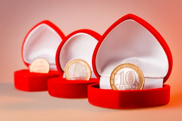 Red gift boxes with one euro, ten roubles and one cent coins. Focus on rouble coin, the official currency of Russian Federation. — Zdjęcie stockowe
