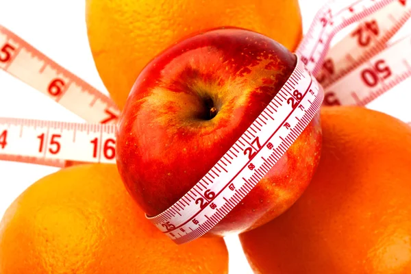 Three oranges and apple with tailor's ruler. Fruit healhy vitamin diet helps to lose weight. — Stock Fotó