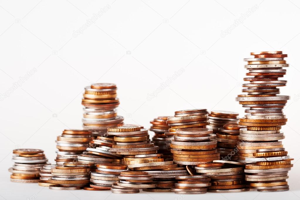 Big heap of columns of different coins on white background. May be used as symbol of increase in wealth.