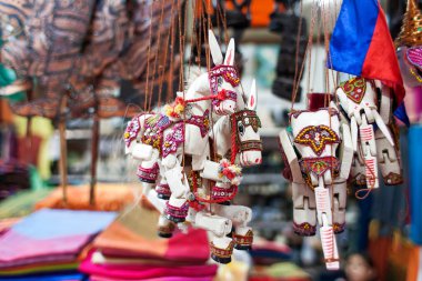 Sale of souvenirs in the market, Siem Reap, Cambodia. Funny handmade wooden puppets donkeys and elephants with bright colorful harness.