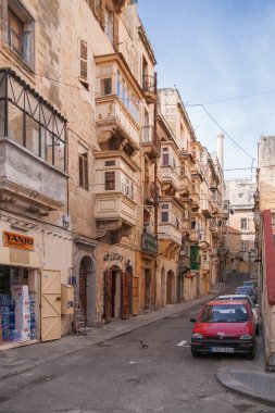 Valletta, Malta - Şubat 20, 2010. Eski sokak Valletta, Malta için. Eski moda balkon, oyma taş duvarlar ve kemerler ile dar sokak.