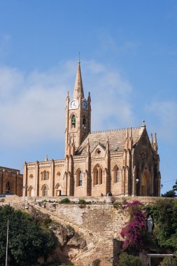 Mgarr harbor with view on church to Our Lady of Lourdes on top of the hill. Gozo island, Malta.