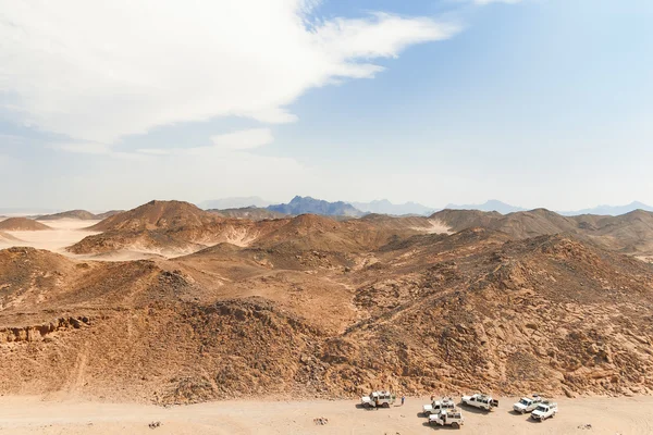 Beautiful Desert Landscape of Egypt. Safari cars go on the road between mountains.