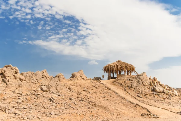 Paisaje del desierto de Egipto. Cabaña solitaria, arena amarilla, montañas, nubes y cielo azul . — Foto de Stock