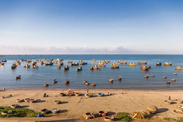 Pueblo pesquero, mercado y coloridos barcos de pesca tradicionales cerca de Mui Ne, Binh Thuan, Vietnam. Temprano en la mañana, los pescadores flotan a la costa con una captura . —  Fotos de Stock