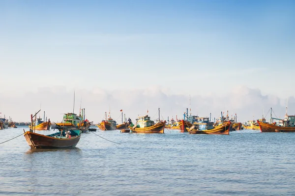 Pueblo pesquero, mercado y coloridos barcos de pesca tradicionales cerca de Mui Ne, Binh Thuan, Vietnam. Temprano en la mañana, los pescadores flotan a la costa con una captura . — Foto de Stock