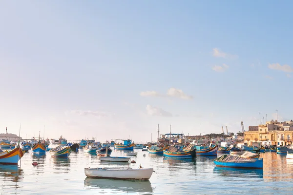 Coloridos barcos típicos - pueblo tradicional de pescadores mediterráneos en el sureste de Malta. Temprano en la mañana de invierno en Marsaxlokk, Malta . — Foto de Stock
