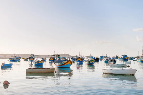 Coloridos barcos típicos - pueblo tradicional de pescadores mediterráneos en el sureste de Malta. Temprano en la mañana de invierno en Marsaxlokk, Malta . — Foto de Stock