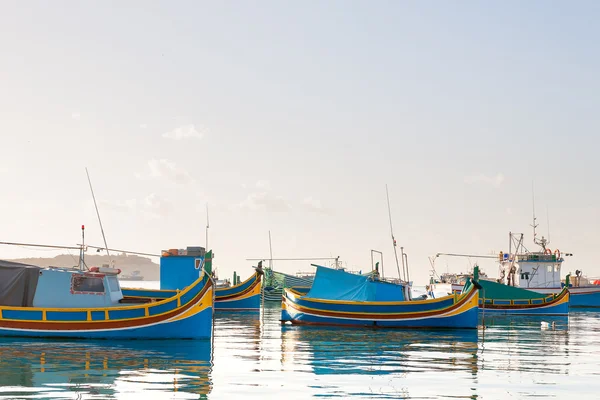 Coloridos barcos típicos - pueblo tradicional de pescadores mediterráneos en el sureste de Malta. Temprano en la mañana de invierno en Marsaxlokk, Malta . — Foto de Stock