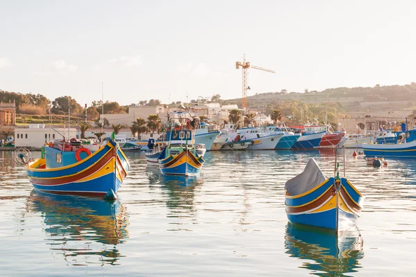 Coloridos barcos típicos - pueblo tradicional de pescadores mediterráneos en el sureste de Malta. Temprano en la mañana de invierno en Marsaxlokk, Malta . — Foto de Stock