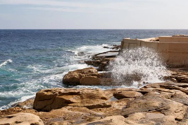 Las olas golpearon la costa rocosa. El agua inundó las depresiones en las rocas . — Foto de Stock