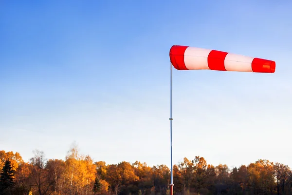 Una paleta de viento rojo contra un cielo azul claro en el día de otoño . — Foto de Stock