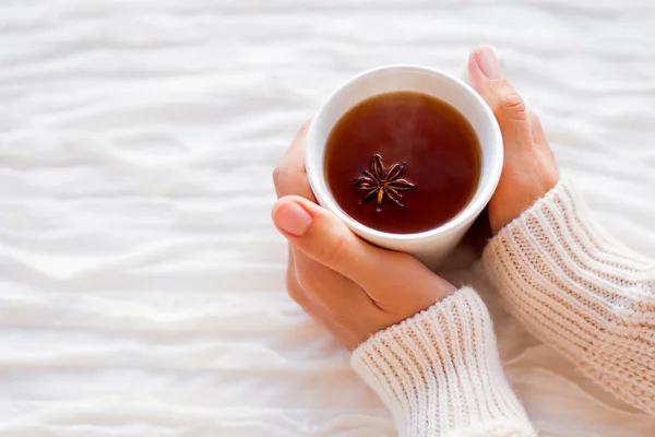 Vrouwen houdt een kop van hete thee met anijs ster. Gezellige ochtend thuis. — Stockfoto