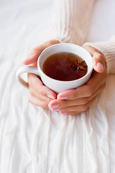 Vrouwen houdt een kopje thee met anijs ster. Gezellige ochtend thuis. — Stockfoto