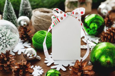 Noel ve yeni yıl arka plan sunar, kurdeleler, topları ve ahşap arka plan üzerinde farklı yeşil süslemeleri ile. Beyaz kurdele ile mevcut ve metniniz için açık yüzey. Yukarı alay.