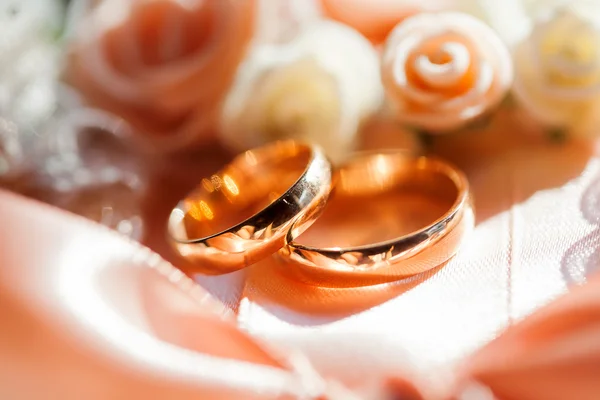 Pırlantalı altın alyans ipek kumaş üzerine gül ile yalan. Aşk ve evlilik sembolü. — Stok fotoğraf
