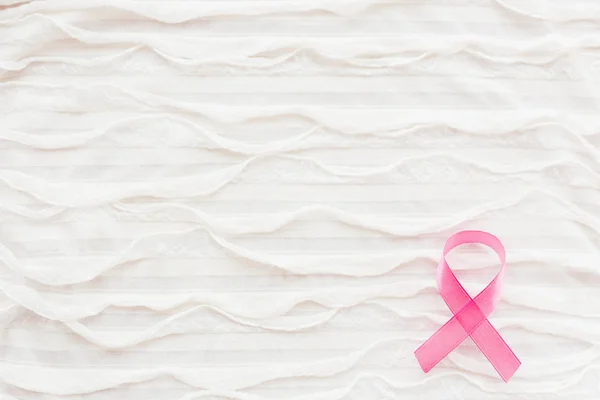 Vitt tyg bakgrund med RYSCH. Rosa bandet - symbol för bröstcancer medvetenhet. Bra som bakgrund för Världscancerdagen affischer, tryckt material. Plats för text. — Stockfoto