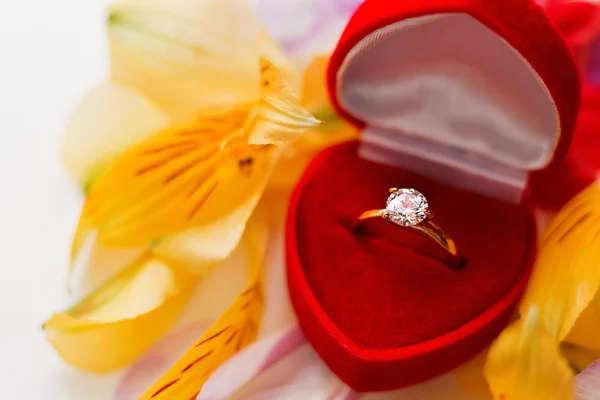 Anel de diamante de noivado em caixa de presente vermelho na pilha de pétalas de flores. Símbolo de amor e casamento . — Fotografia de Stock