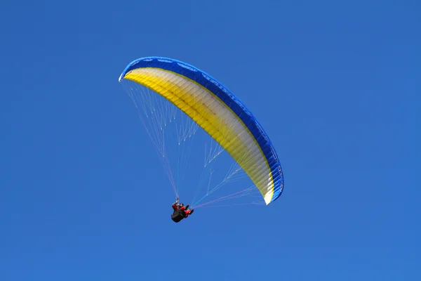 Sárga siklóernyővel a mély kék ég ellen — Stock Fotó
