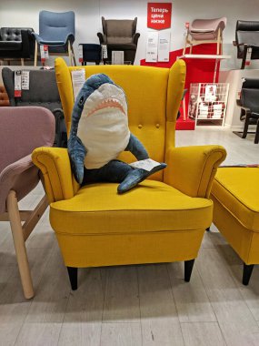 Moskova, Rusya - 07 Mart 2020: Moskova 'daki IKEA mağazasındaki sarı koltukta yumuşak bir köpekbalığı oyuncağı oturuyor