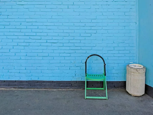 Zielone Krzesło Betonowa Urna Stoją Tle Ściany Niebieskiej Cegły — Zdjęcie stockowe