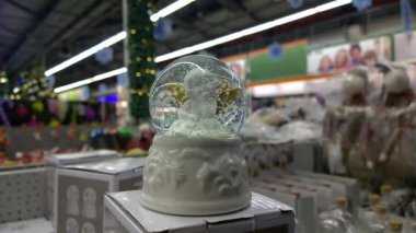Melekli cam top oyuncağı ve içinde kar yağıyor.