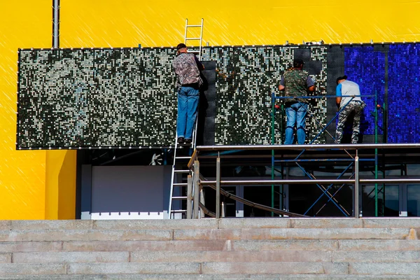 Bir reklam billboard üç işçi yüklemek