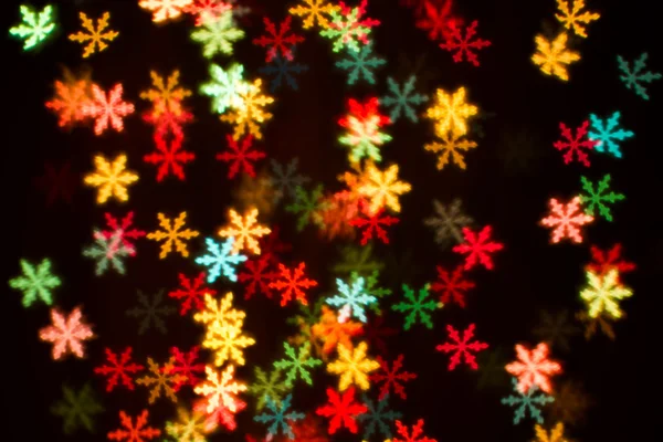 Blurring lights bokeh background of colorful snowflakes — Stock Photo, Image