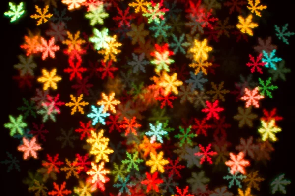 Blurring lights bokeh background of colorful snowflakes — Stock Photo, Image