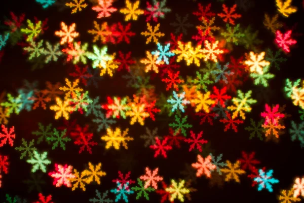 Blurring lights bokeh background of colorful snowflakes — Stock Photo, Image