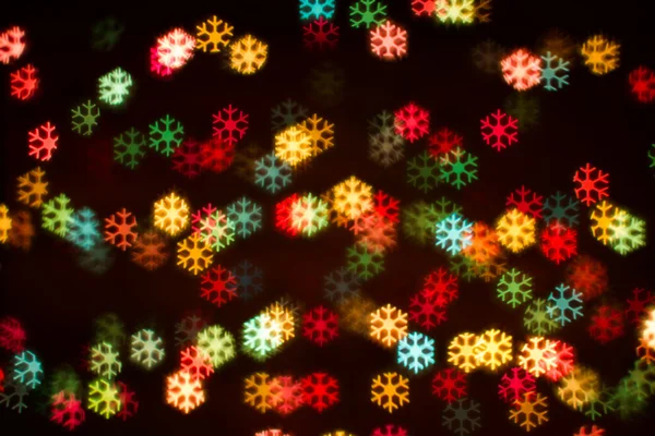 Blurring lights bokeh background of colorful snowflakes — Stock Photo, Image