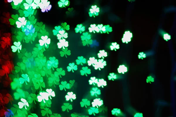 Blurring lights bokeh background of green clovers. Happy Saint Patrick's Day Background — Stock Photo, Image
