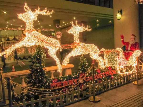 Noel Baba ren geyikleri tarafından çekilen bir kızağa biniyor.