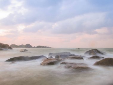 Quang Ngai, Vietnam 'da bulutlu ve soğuk bir günde kayalık bir plajın fotoğrafı.