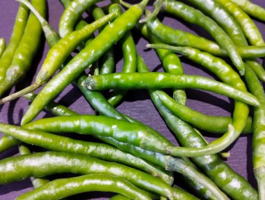 Yakından bakınca bir demet taze, parlak yeşil biber görünüyor..