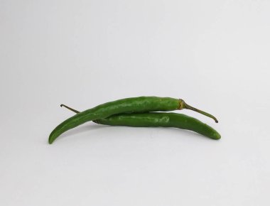 İki uzun yeşil biber üst üste yatay olarak dururlar..