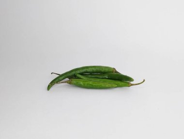 Düz beyaz arkaplanda sıralanmış taze yeşil biber kümesi..